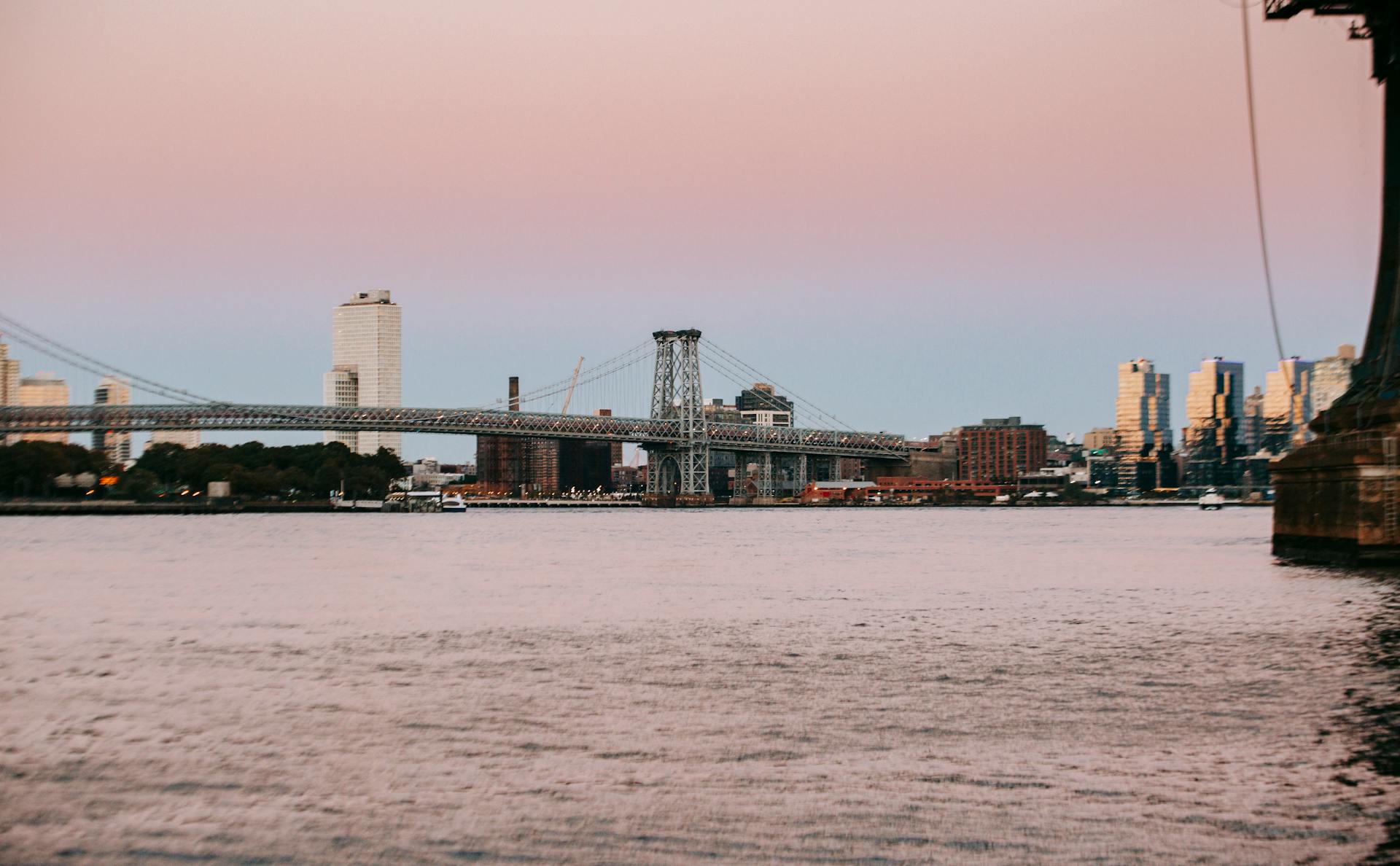 Williamsburg Bridge across East River placed in New York City at sunset