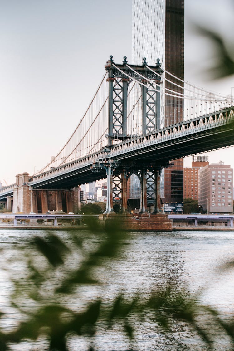 Aged Suspension Bridge Against Modern Skyscraper