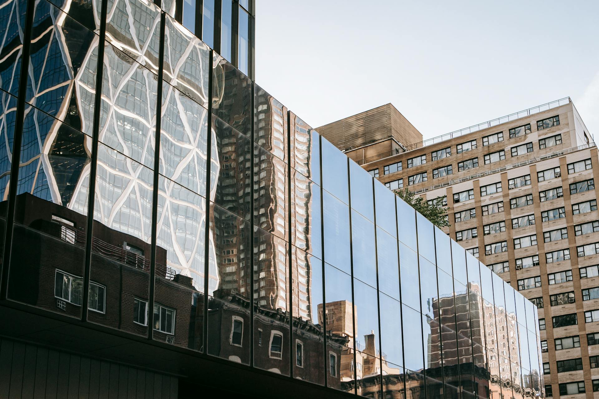 Urban cityscape with modern skyscraper architecture and reflections on glass facade.