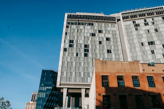 Low angle view of a contemporary high-rise building with a clear blue sky.