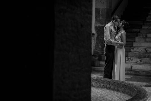 Grayscale Photo of a Romantic Couple Kissing