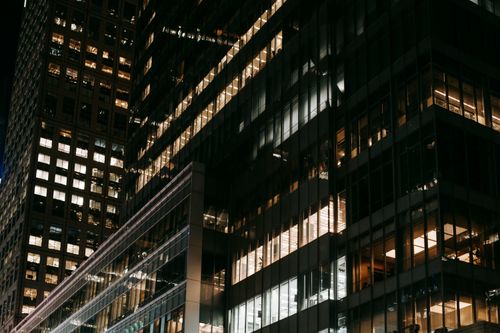 Free Exterior of modern glass skyscrapers with illuminated windows at dark night in urban city district Stock Photo
