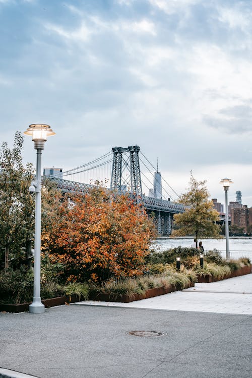 Free Scenery of urban New York City district with famous Manhattan Bridge in early autumn under cloudy sky Stock Photo