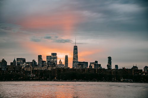 Modern New York City district with famous typical skyscrapers situated on East River coast at picturesque sunset