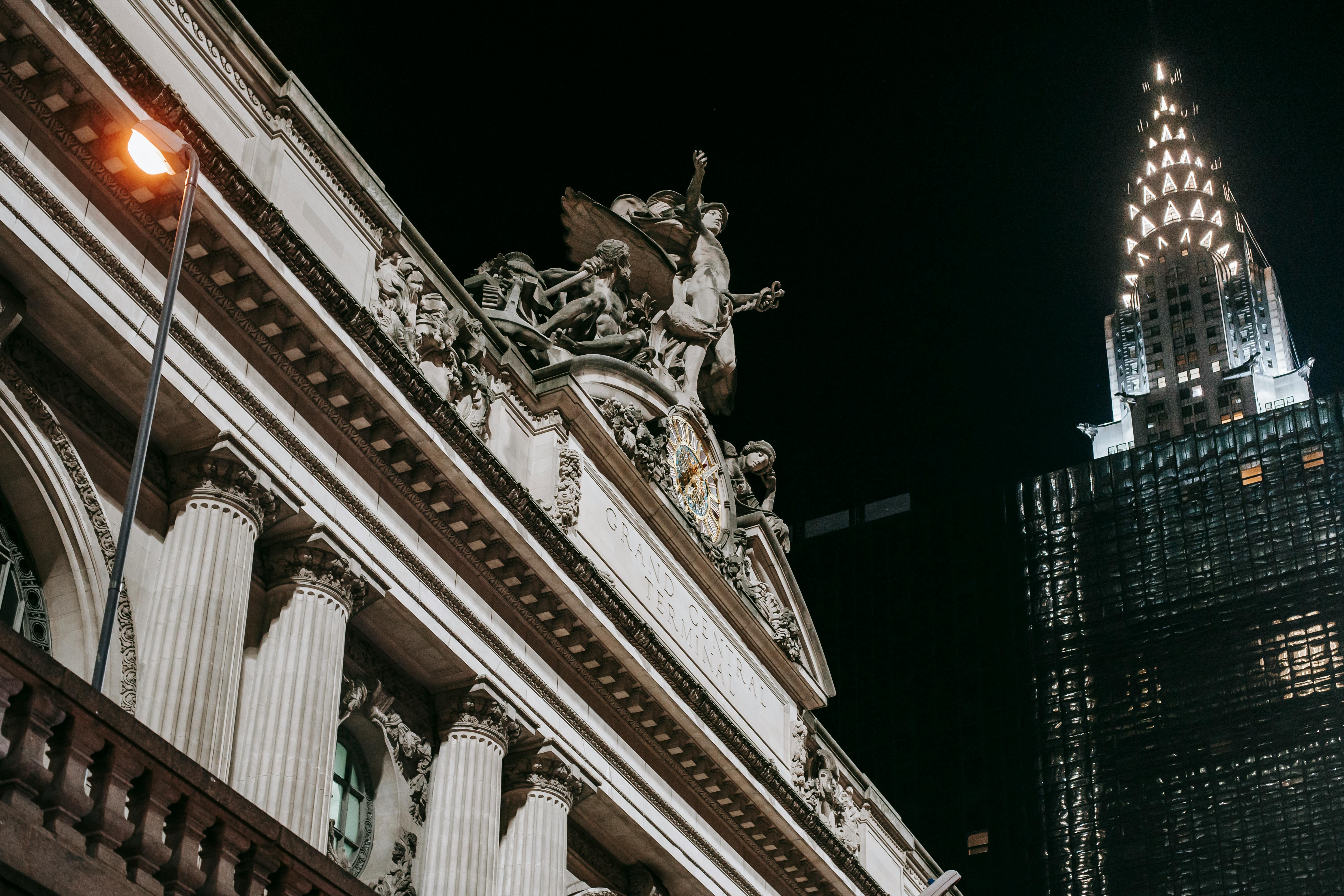 historic stone building near modern glass tower at night