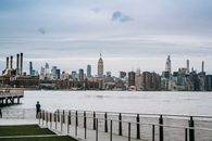 Man standing on embankment of river in big city