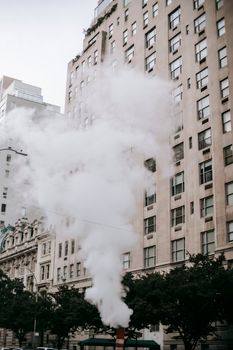 在现代城区街道上，高塔低角度矗立，蒸汽缭绕