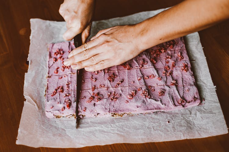 Hands Cutting Pink Cake