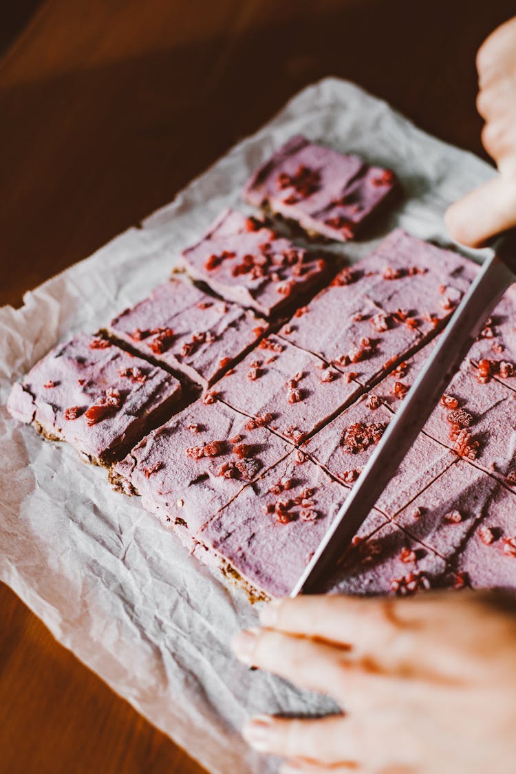 Person Cutting Pink Cake With Knife