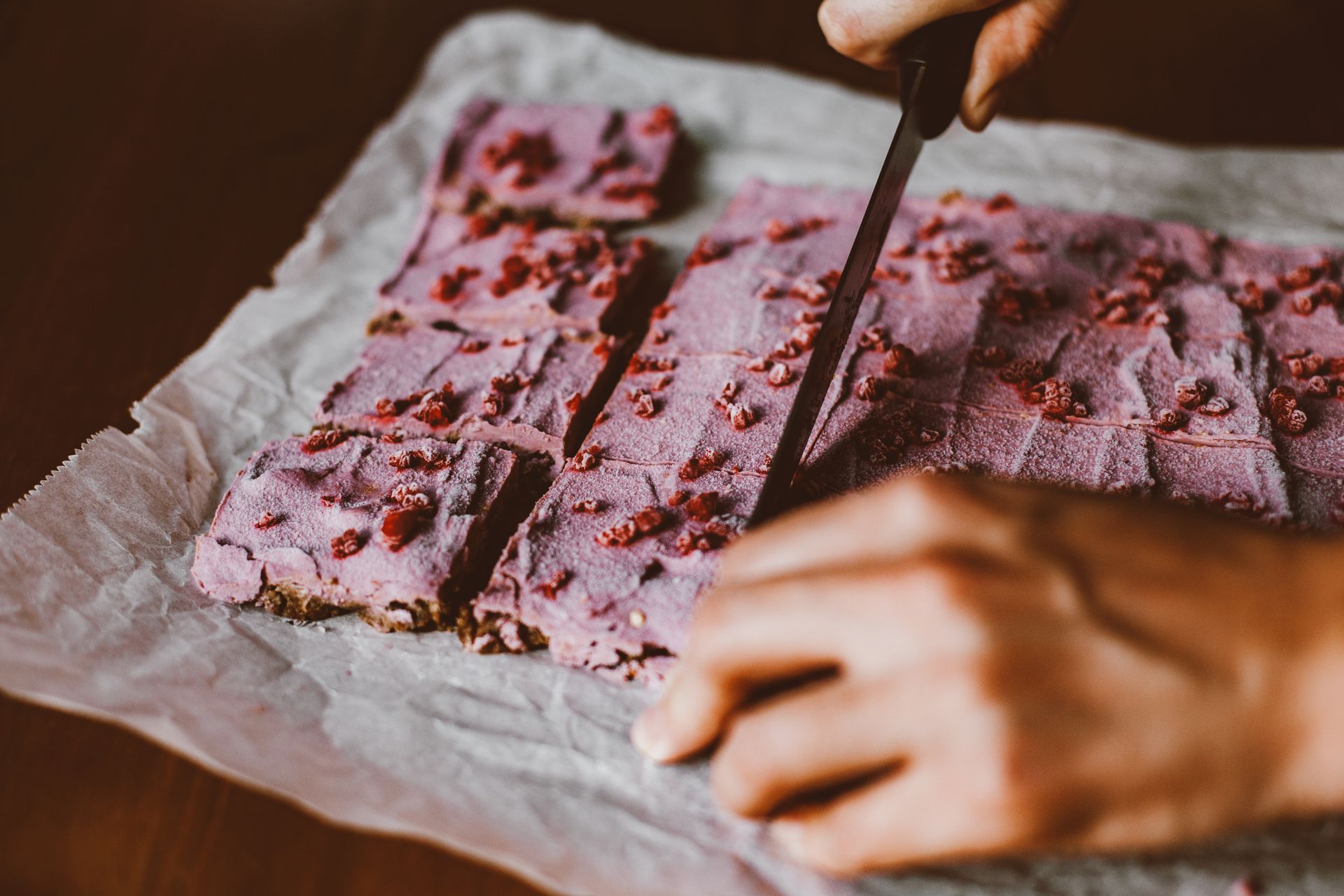 Hands of Person Cutting Pink Cake