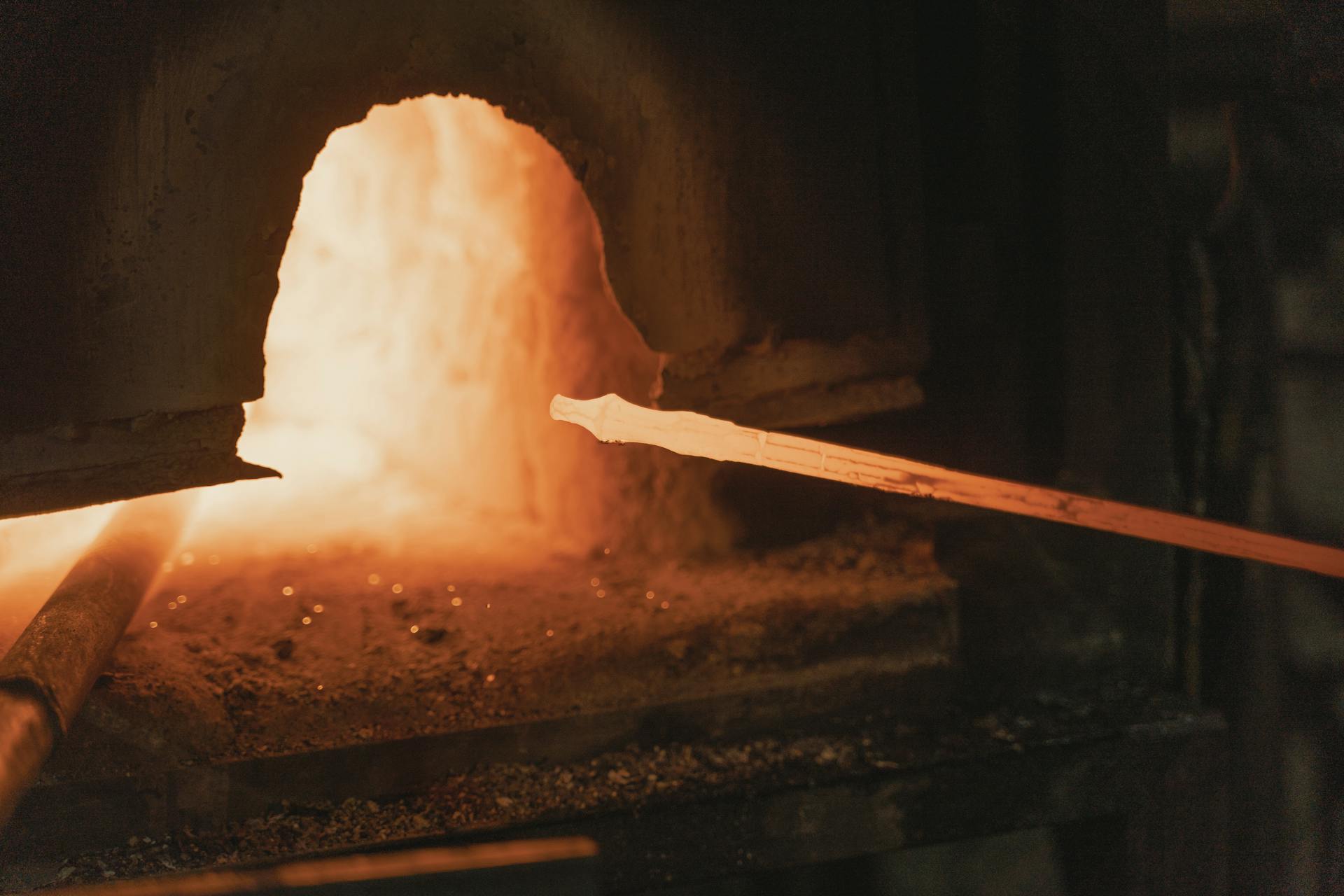 A close-up view of steel being heated and forged in a traditional blacksmith's forge.