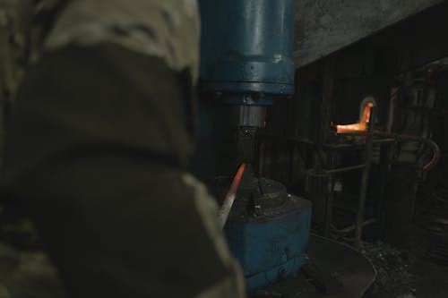 Person Forging a Hot Metal with a Machine