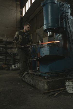 A metalsmith working steel under a press — Tima Miroshnichenko on Pexels