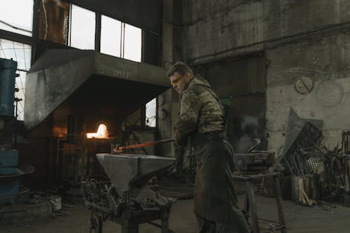 Man in Brown Jacket Holding Black Metal Frame