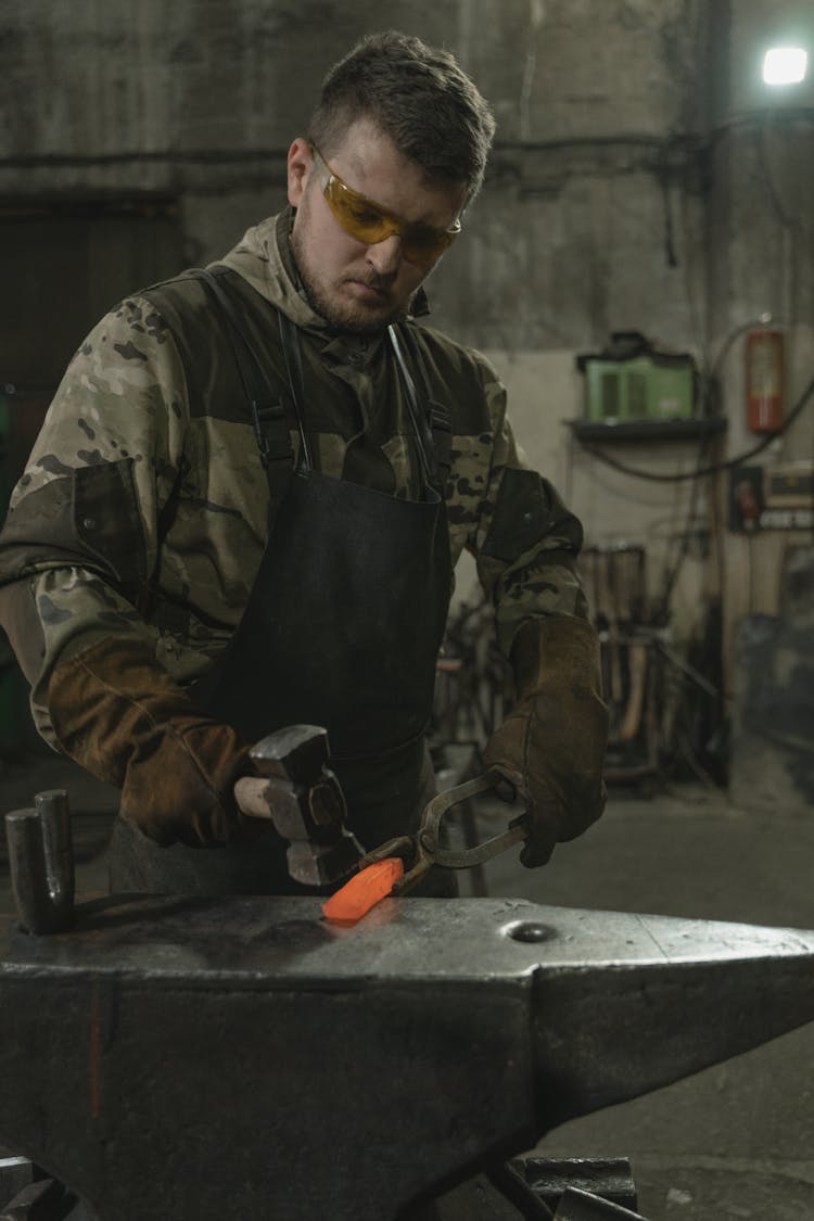 Blacksmith Hammering A Hot Piece Of Metal 
