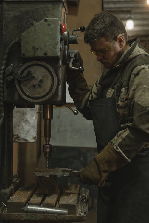 Man in Green and Brown Camouflage Uniform Holding Black and Gray Metal Machine