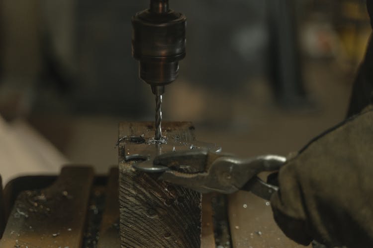 Close-Up Shot Of A Person Drilling A Metal