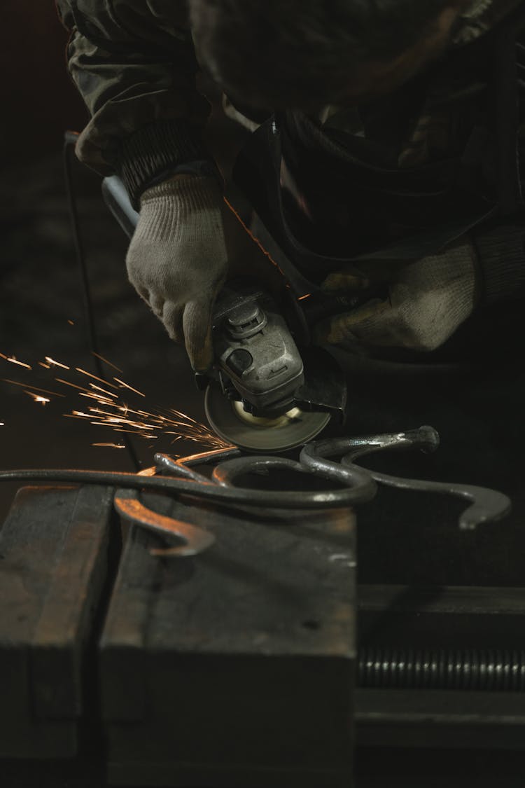 A Person Grinding A Metal