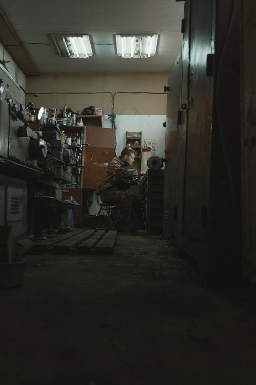 Free A focused craftsman working with a grinder in a cluttered workshop, illustrating industry and craftsmanship. Stock Photo