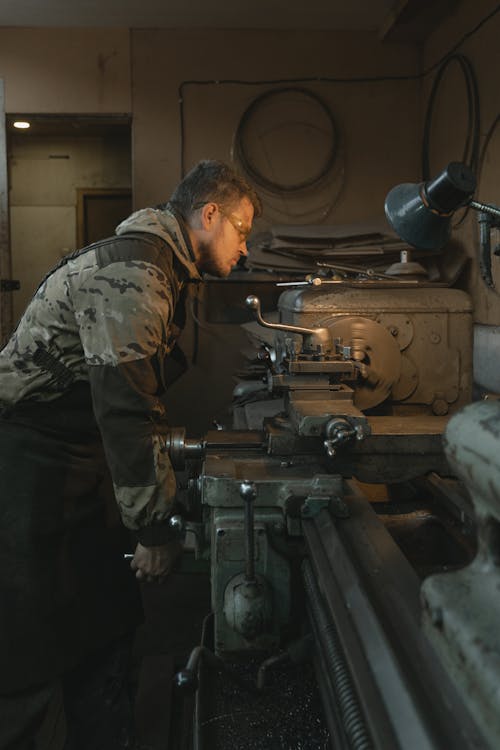 Man in Gray and Black Camouflage Jacket and Pants Holding Black Metal Machine