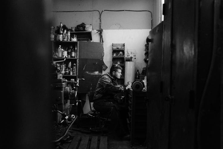 Grayscale Photo Of A Man In A Workshop