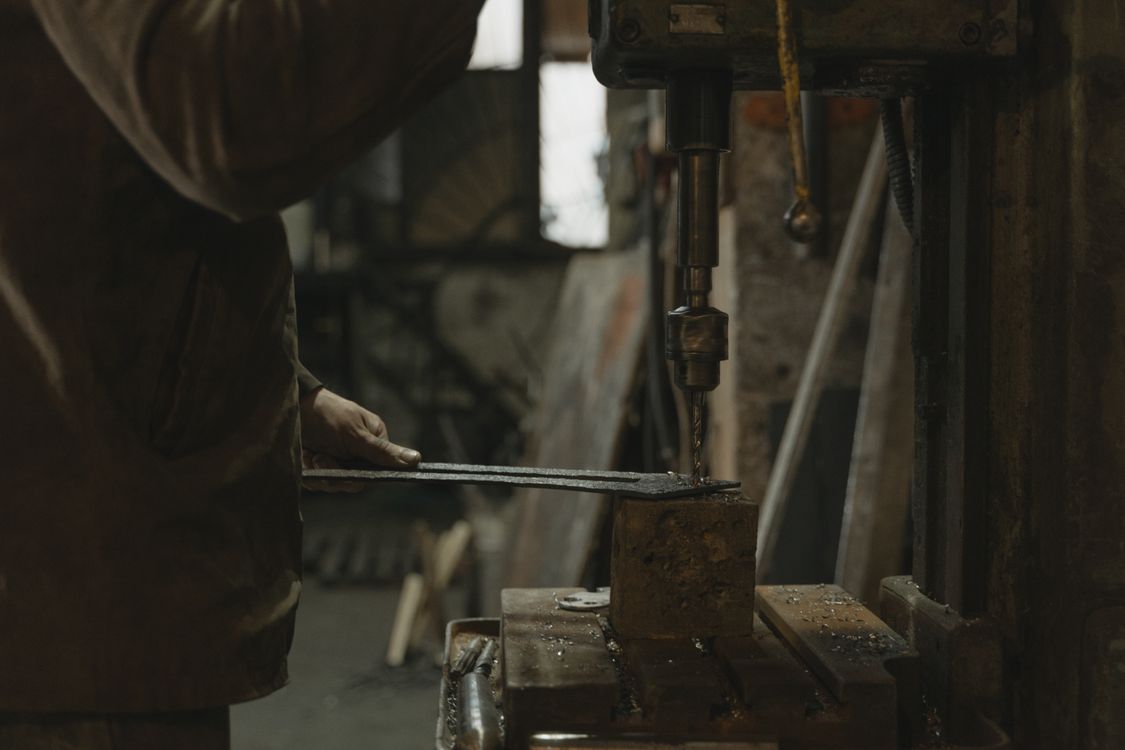 Man in Brown Jacket Holding Black Metal Tool · Free Stock Photo