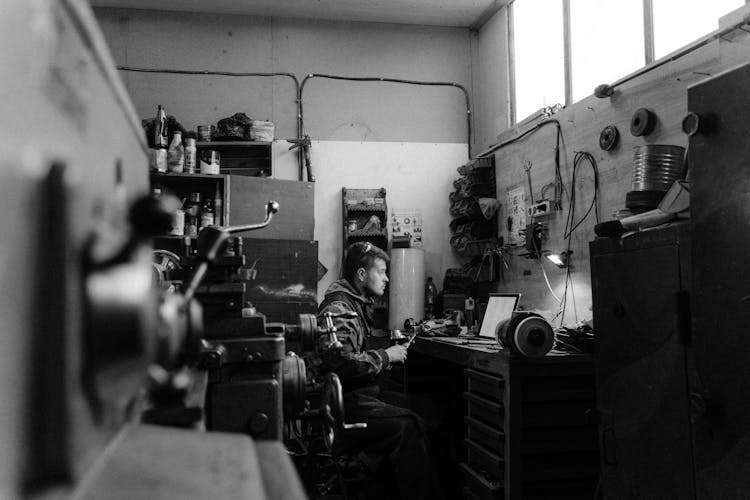 Grayscale Photo Of A Man In A Workshop