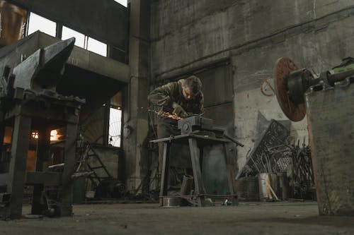 A Man Using Grinding a Metal