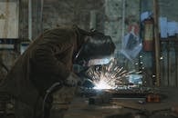 A Person Welding at a Workshop