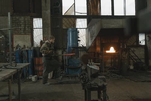 Man in Gray Jacket Standing Near Fire