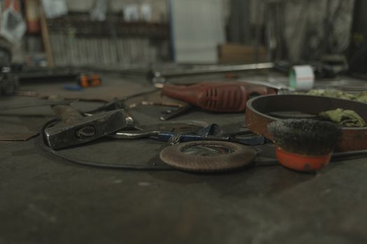 A selection of various tools scattered on a workbench in an industrial setting.