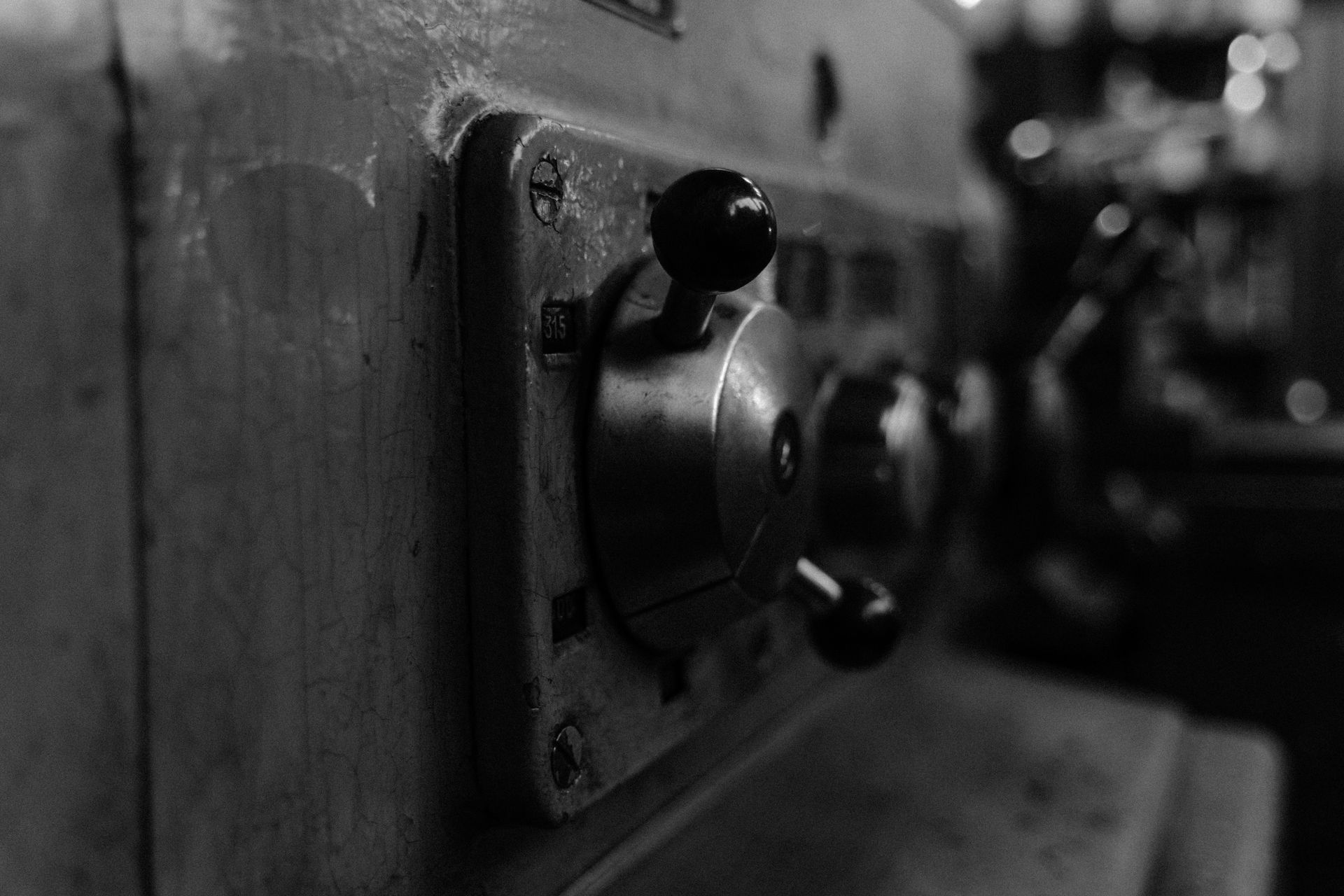 Detailed view of vintage machine control panel in black and white.