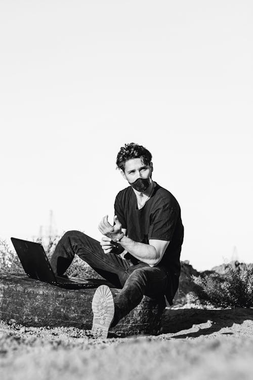 Free Portrait of a Man Sitting Outdoors with a Laptop Stock Photo