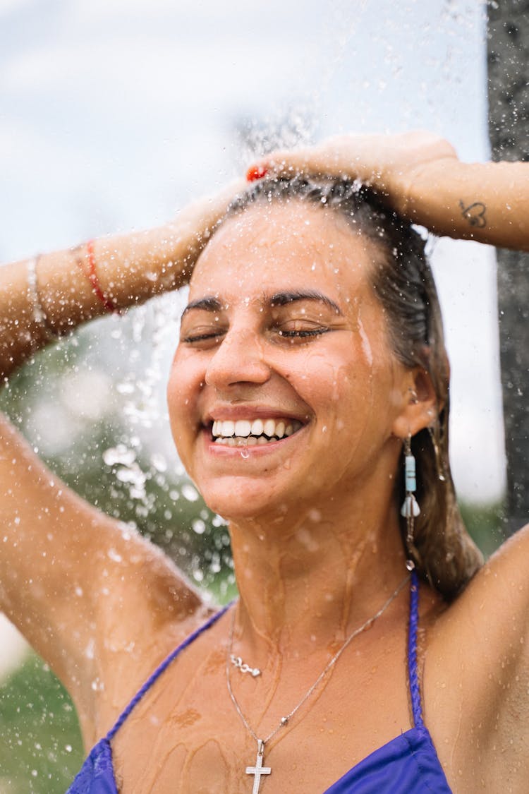 A Woman Smiling While Showering 