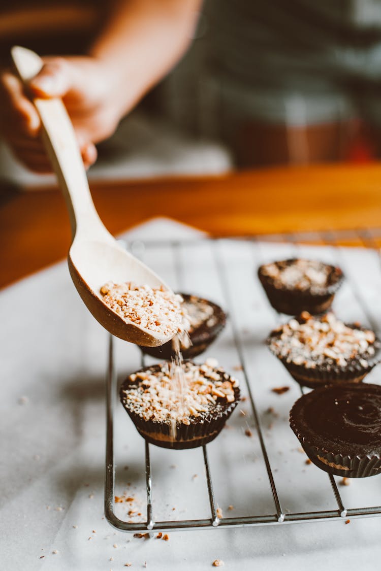 Person Decorating Cupcakes With Sprinkles