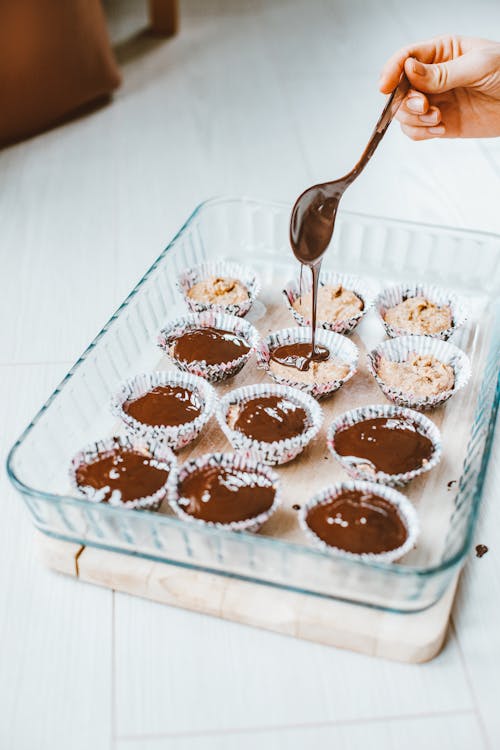 Free Pouring Chocolate over Cupcake Batter Stock Photo