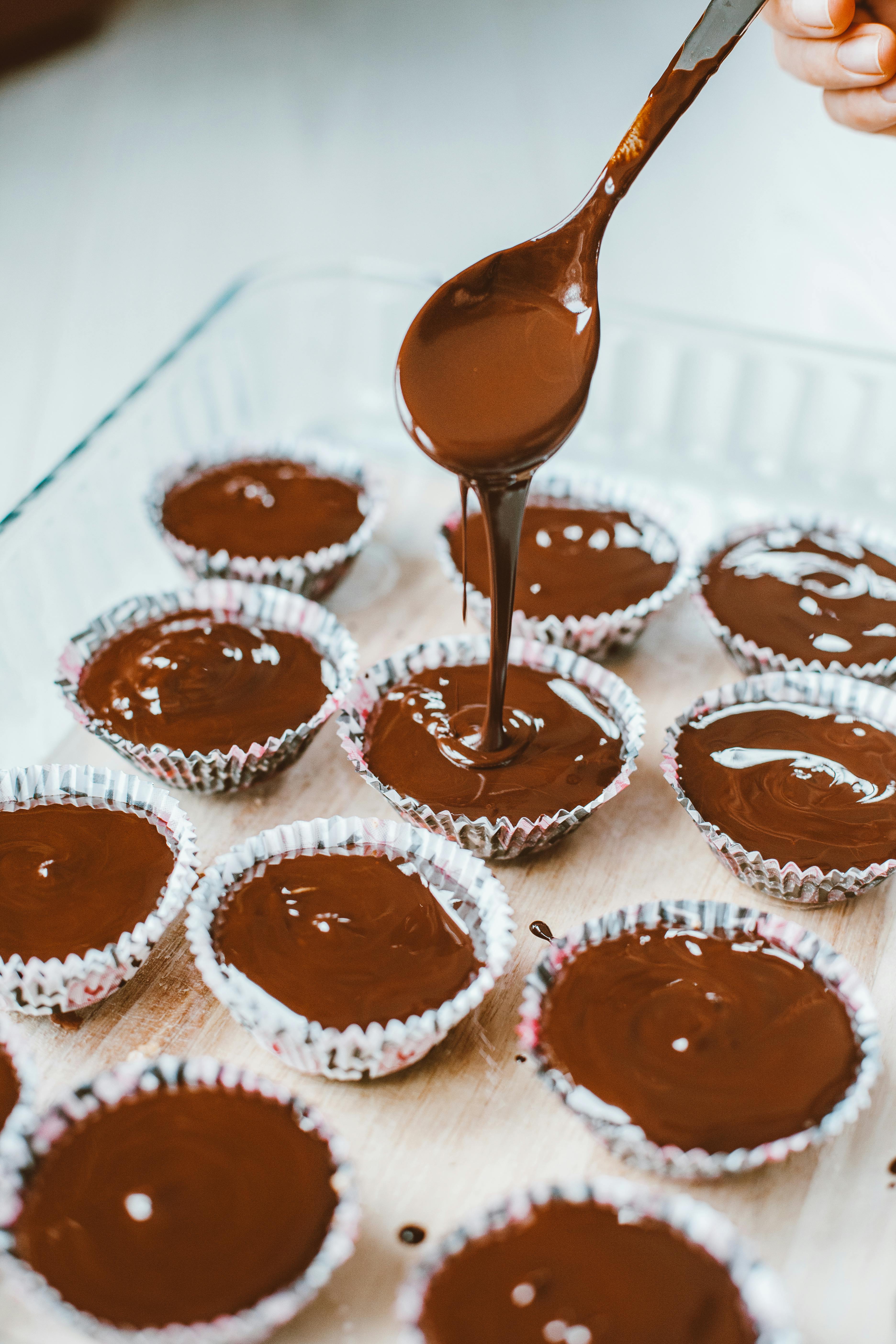 pouring muffin batter into muffin forms