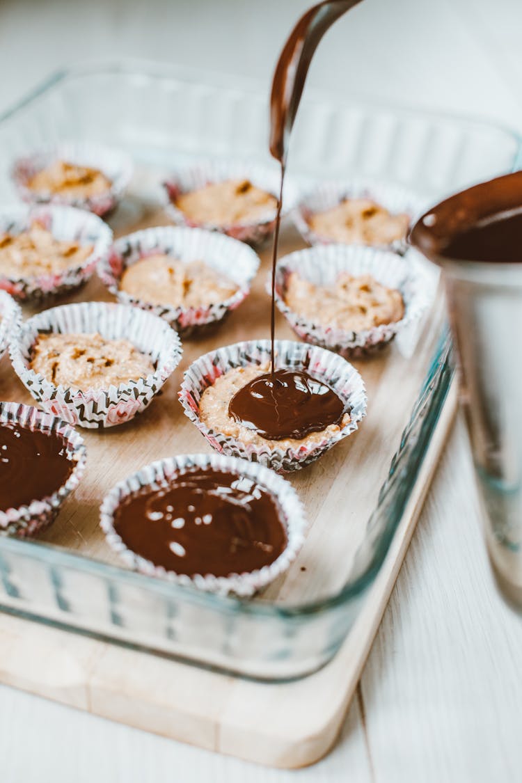 Chocolate Icing Pouring Over Cupcakes