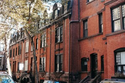 Row of brick townhouses on a tree-lined street — photo by Charles Parker on Pexels