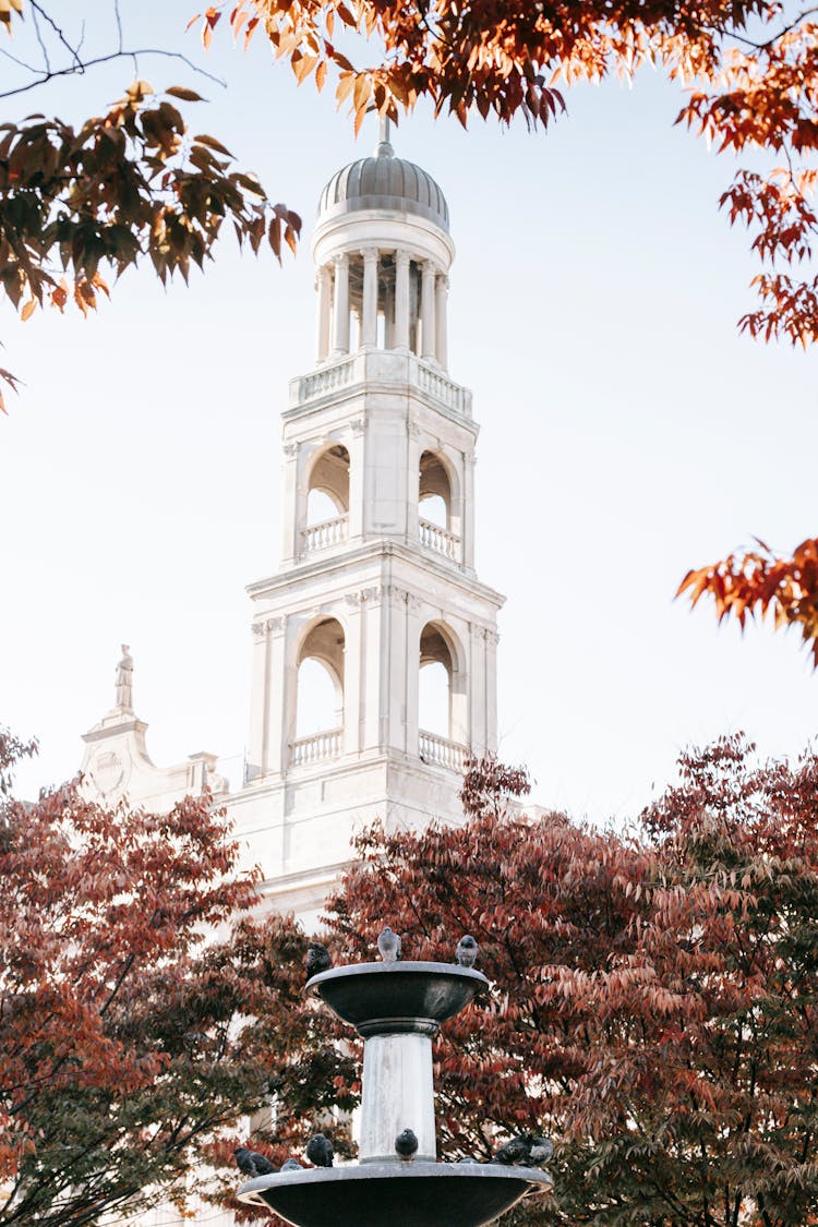 Facade Of Aged Catholic Parish Church With Domed Tower In Sunlight