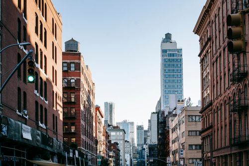 Free District of New York with aged residential buildings and modern commercial skyscrapers against cloudless blue sky Stock Photo