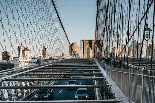 Metal suspension bridge with traffic in city
