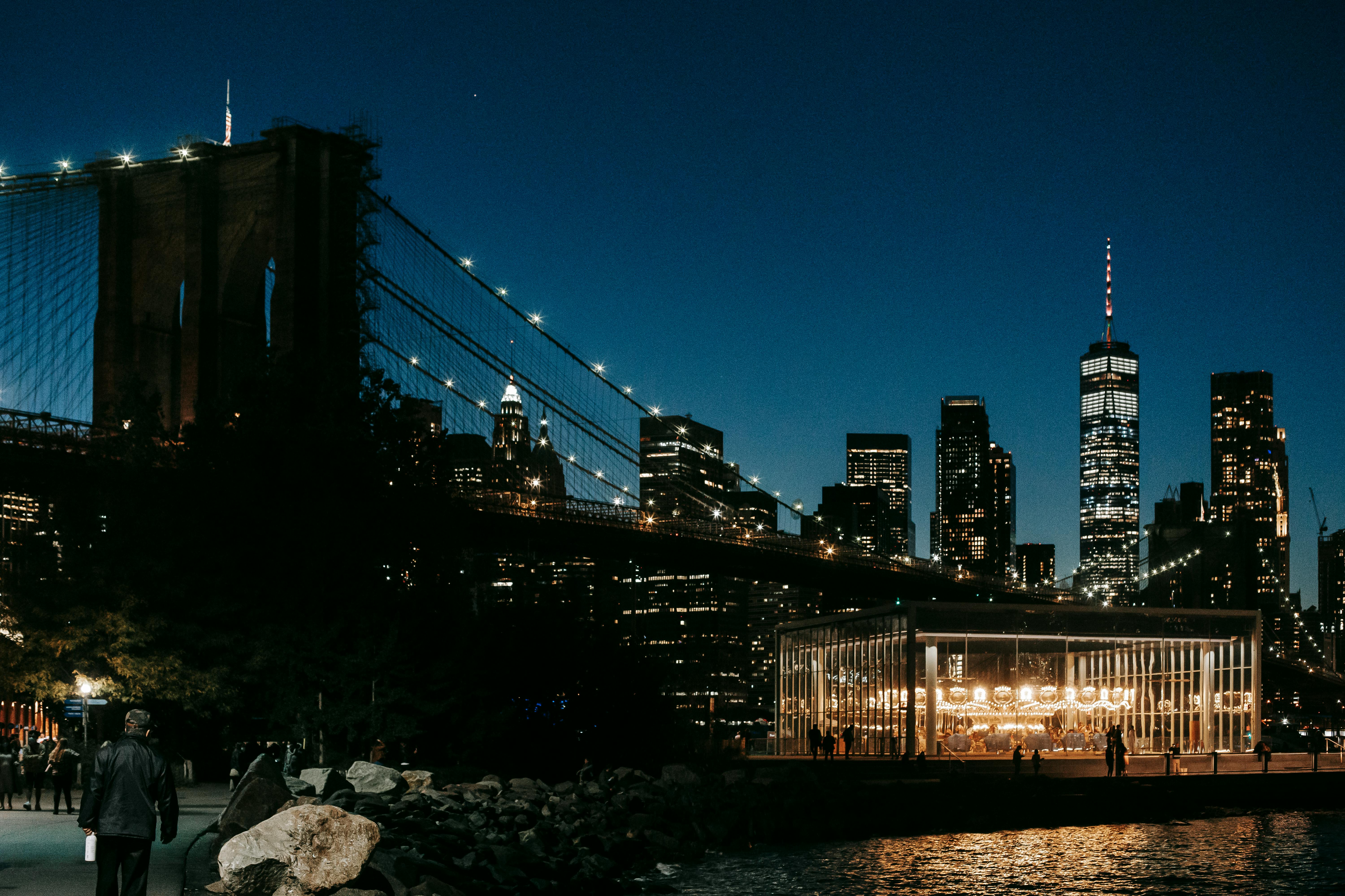 skyscrapers behind bridge and embankment at night