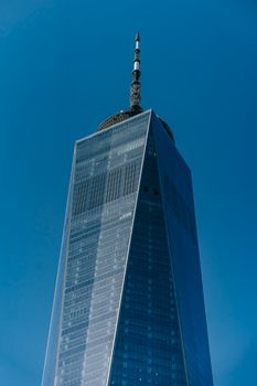从高层建筑的玻璃立面下方俯瞰，屋顶塔楼映衬着清澈的蓝天