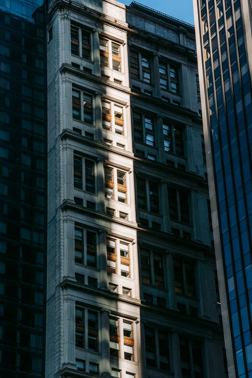 Free From below of old residential condominium complex between contemporary high rise buildings with glass walls Stock Photo