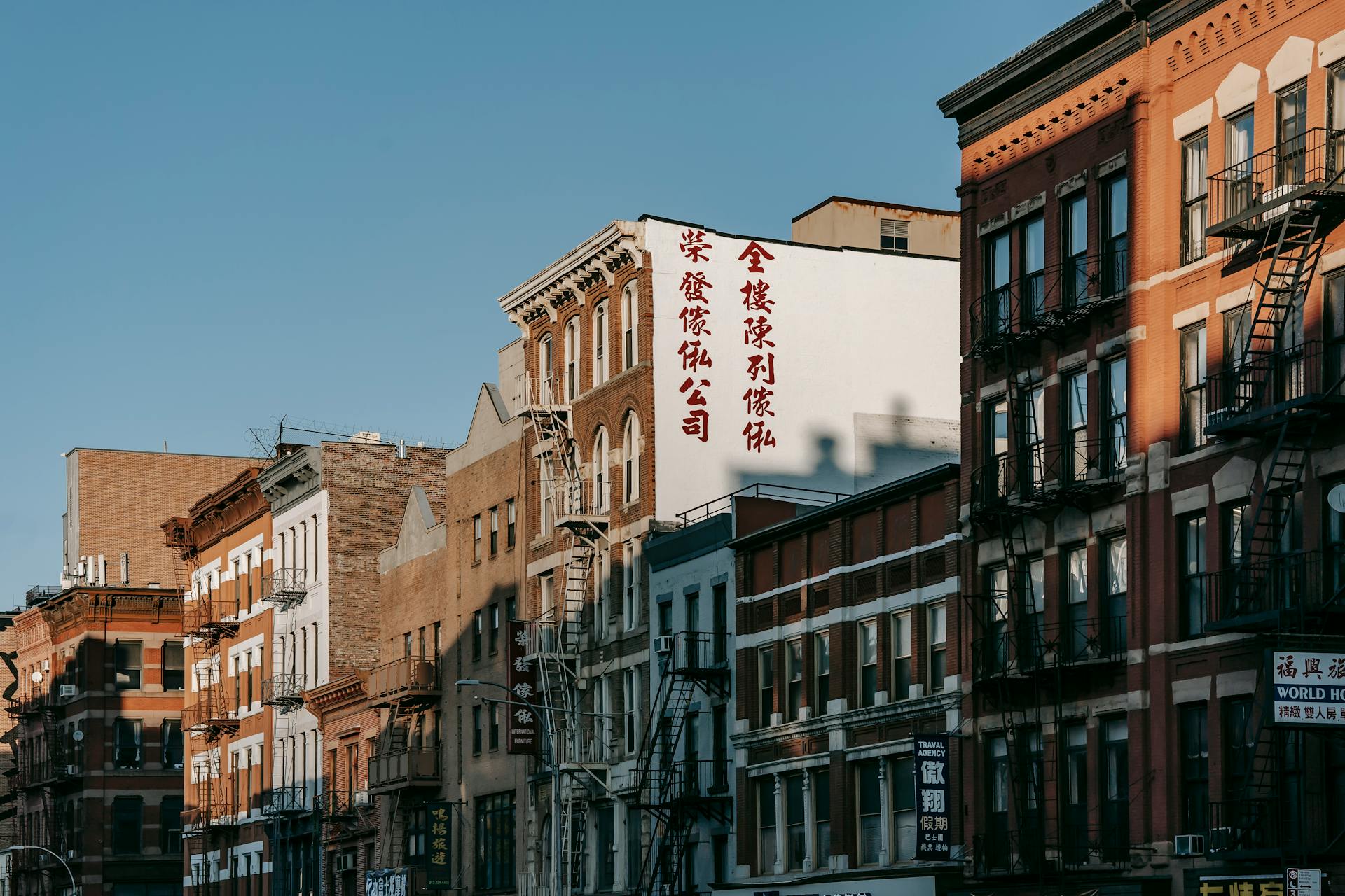 Exterior of apartment buildings with brick facades and emergency ladders on street of modern city