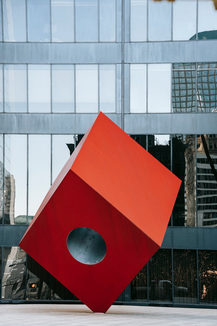 Futuristic Red Cube Sculpture On Modern City Square