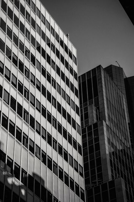 Black and white from below contemporary glass tall buildings located in central city district in daytime