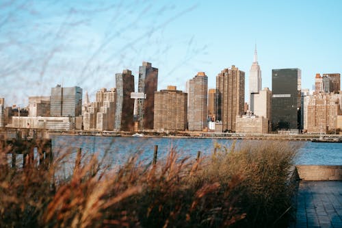 Free Calm Hudson River flowing near modern district with high rise buildings placed in New York under cloudless blue sky in daytime Stock Photo