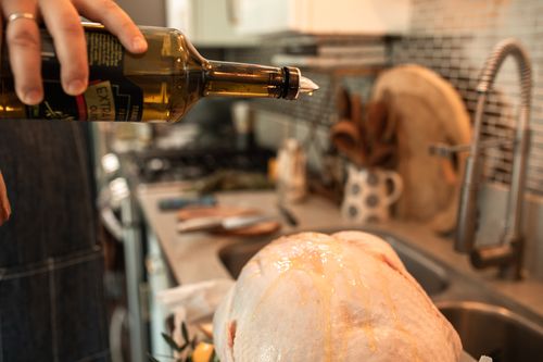 Free A close-up of a turkey being prepared with olive oil in a cozy kitchen setting. Stock Photo